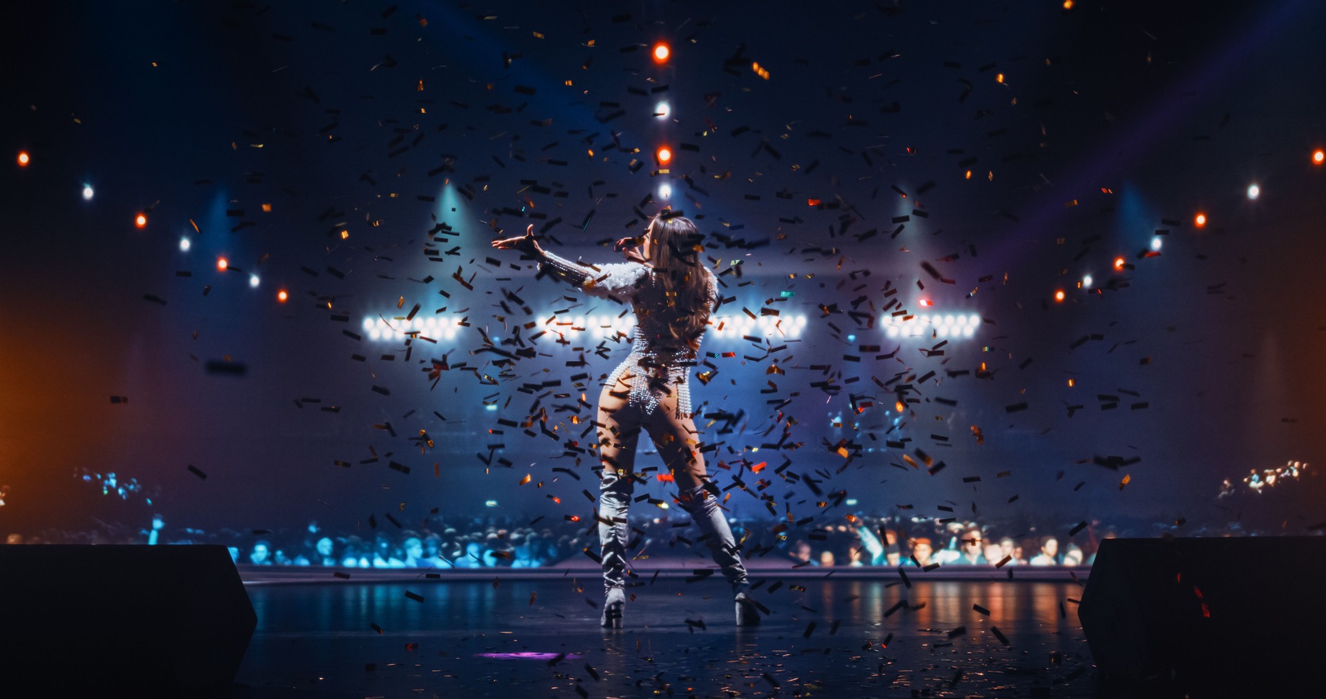 Female Pop Artist Performing Live Concert on Stage, Illuminated by Spotlights. Epic Cinematic Performance Capturing Artist's Passion and Energy. Crowd of Diverse Fans Dancing in the Background
